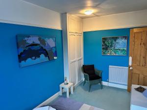 a bedroom with blue walls and a chair and a table at 3BD Victorian Townhouse Near Norfolk Broads 4A, 2C in Beccles