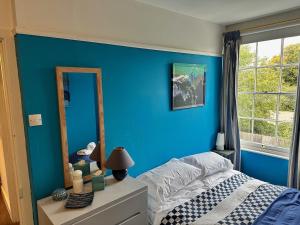 a blue bedroom with a bed and a mirror at 3BD Victorian Townhouse Near Norfolk Broads 4A, 2C in Beccles +22 photos
