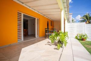 a patio with an orange wall and a table at Vaniya in Fonds dʼ Or +7 photos