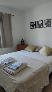 een wit bed met twee handdoeken erop bij SILVESTRE - Departamento in Cordoba