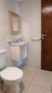 een badkamer met een toilet, een wastafel en een deur bij SILVESTRE - Departamento in Cordoba