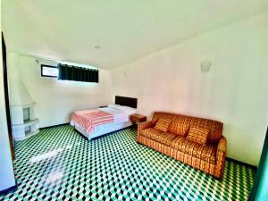 a bedroom with a bed and a couch in a room at Rancho La Querencia in Tala
