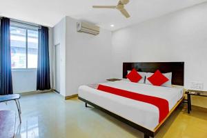 a bedroom with a large bed with red pillows at Hotel O Meridian Grand in Shamshabad