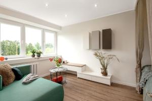 a living room with a green bed and a window at Sunshine apartamentai in Alytus