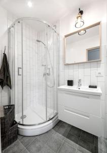 a white bathroom with a shower and a sink at Sunshine apartamentai in Alytus