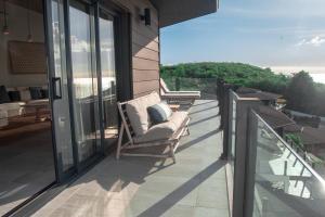 einen Balkon mit einem Stuhl auf einem Haus in der Unterkunft Tamarind Hills Resort & Villas in Johnsons Point