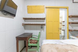 a room with a bed and a desk and a tv at Pousada Flor de Olinda in Olinda