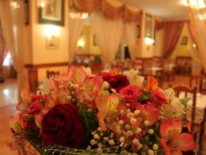 um vaso de flores sentado numa mesa em Alexandria Hotel em Pryluky