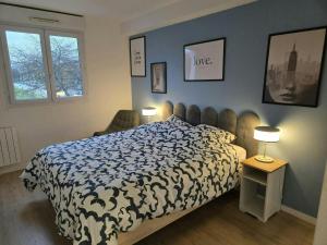 a bedroom with a bed with a black and white comforter at The Blue Sky Haven 2 - 5min to Disneyland in Serris