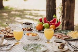 Una mesa cubierta con platos de comida y vasos de jugo de naranja. en El Pinar Caballeriza, en San Rafael