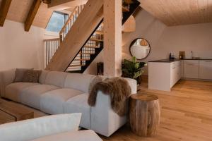 a living room with a couch and a wooden floor at Hidden Retreats The GlacierDoor in Frutigen