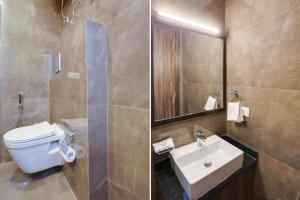 a bathroom with a toilet and a sink and a mirror at Super Townhouse MA-32 in Gurgaon