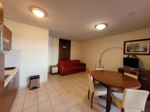 a living room with a table and a red couch at Bienvenue au 122 in Mandelieu-la-Napoule