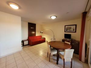 a living room with a table and a red couch at Bienvenue au 122 in Mandelieu-la-Napoule