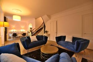 a living room with two blue chairs and a table at Hôtel particulier Le Trémolières in Cholet