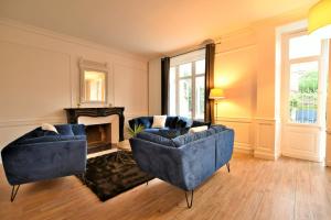 a living room with two blue couches and a fireplace at Hôtel particulier Le Trémolières in Cholet