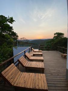 a group of wooden benches sitting on a deck at Villa Macacos in Nova Lima