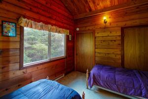a bedroom with a bed in a log cabin at The Beanstalk in Otis