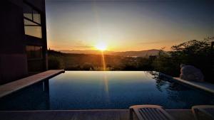 una piscina con un tramonto sullo sfondo di La Moradita Villa Carlos Paz a Villa Carlos Paz