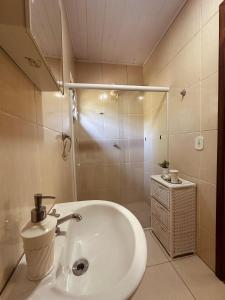 a bathroom with a white sink and a shower at Hostel 040 in Itaipava +60 photos
