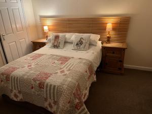 ein Schlafzimmer mit einem großen Bett mit zwei Nachttischen in der Unterkunft Ford Village Bed & Breakfast in Ford