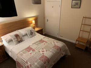 ein Schlafzimmer mit einem Bett mit einer Steppdecke darauf in der Unterkunft Ford Village Bed & Breakfast in Ford