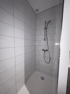 a white bathroom with a shower and a tub at Au Trèfle Dort Gîte in Châtel-Guyon