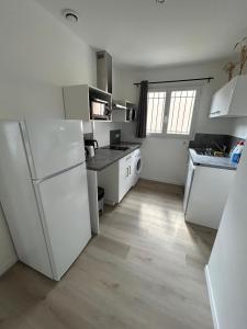 a kitchen with white appliances and a white refrigerator at Au Trèfle Dort Gîte in Châtel-Guyon +6 photos