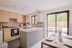Una cocina con una mesa con copas de vino encima. en Modern and Stylish Home away from Home, en Milton Keynes