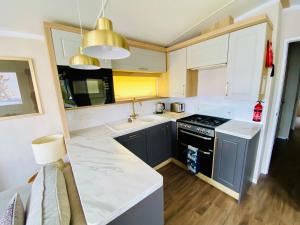 Kuchyň nebo kuchyňský kout v ubytování Beautiful Devon Cliffs Caravan, perfect for exploring Exmouth, Exeter & Sandy Bay beach