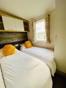 Postel nebo postele na pokoji v ubytování Beautiful Devon Cliffs Caravan, perfect for exploring Exmouth, Exeter & Sandy Bay beach