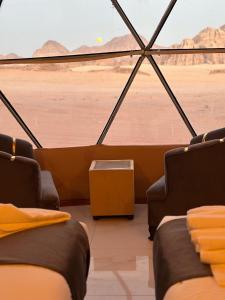 a room with two beds and a view of the desert at Wadi Rum Luxury Hamad & Jeep Tours in Wadi Rum