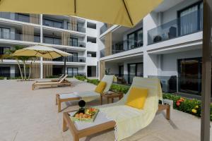 a hotel patio with chairs and an umbrella at Sausalito | Pool View Retreat in Punta Cana