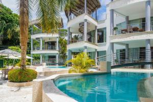 eine Außenansicht eines Resorts mit Swimmingpool in der Unterkunft Hermosa Waves A1 in Playa Hermosa