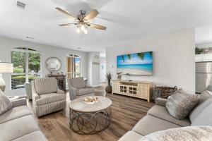 una sala de estar con un sofá y una mesa en Luxury Beach House Steps from Pool and Short Walk to Private Beach Pavilion, en Destin