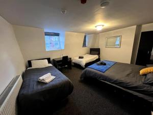 a hotel room with two beds and a table at Luxury, very central and spacious house in Brighton & Hove