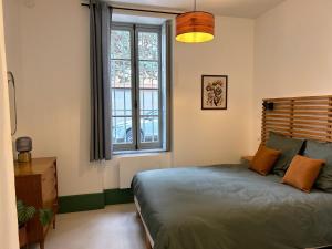 une chambre avec un lit et une grande fenêtre dans l'établissement Le Séquoia, à Autun