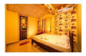 a bedroom with a bed and a wall with pictures at Holy Village Homestay in Neriyamangalam