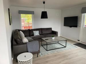 a living room with a couch and a table at Apartment- fjord view, big terrace, close to Moa in Ålesund +18 photos
