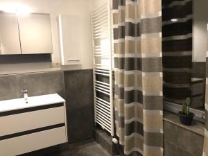 a bathroom with a sink and a shower curtain at Nordsee Pension in Garding +15 photos
