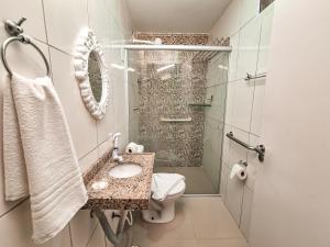 a bathroom with a shower and a sink and a toilet at Pousada Cheiro do Mar in Porto De Galinhas +89 photos