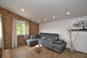 a living room with a couch and a table at Apartments Plomin in Plomin