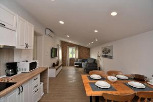 a kitchen and living room with a table in a kitchen at Apartments Plomin in Plomin