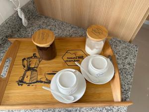 a wooden tray with two cups and saucers on it at Samana Complexes Los Robles VII in Los Paredones