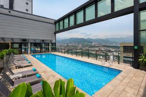 a pool with chairs and a view of the city at Hotel Estelar Square in Medellín