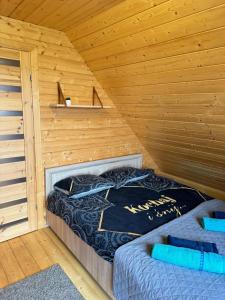 Postel nebo postele na pokoji v ubytování Karmelowe Domki Kaszuby, z jacuzzi na tarasie z widokiem na jezioro