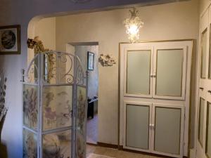 a room with a glass cabinet and a chandelier at La casa del angelo in Servigliano