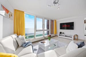 a living room with white furniture and a large window at Strand-Penthouse, 128 qm, Maisonette, Parkplatz in Wilhelmshaven