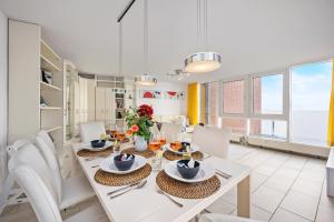 a dining room with a white table and chairs at Strand-Penthouse, 128 qm, Maisonette, Parkplatz in Wilhelmshaven