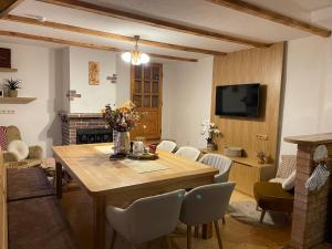 a living room with a wooden table and a fireplace at Chata Margitka in Dúbrava